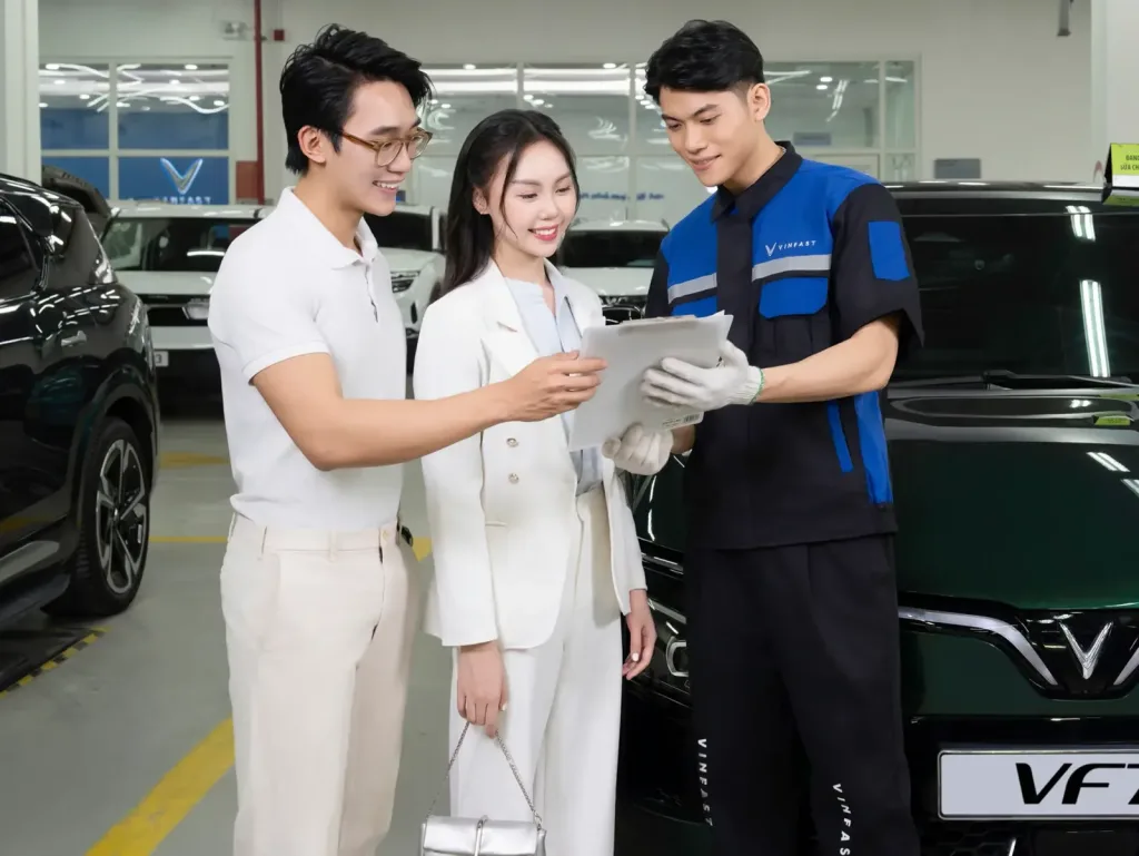 Cố vấn dịch vụ VinFast trao đổi với kh&aacute;ch h&agrave;ng tại xưởng